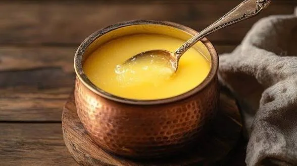Copper bowl filled with pure desi cow ghee and a silver spoon