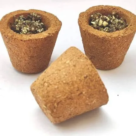 Three hand-moulded cow dung havan cups filled with herbal samagri